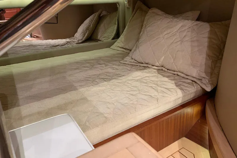 Slide: The Image of Cozy cabin bed in 2015 Jupiter 41 SB yacht with beige bedding and pillows. - 43