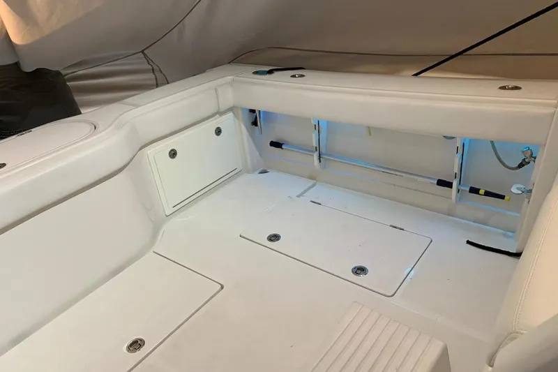 Slide: The Image of Interior of a 2015 Jupiter 41 SB boat with white seating and storage compartments. - 49