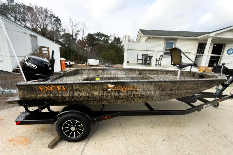 The Image of 2026 Excel Tomahawk 183 boat on trailer, featuring Suzuki outboard motor, parked outdoors. - 0