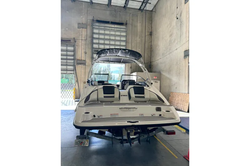 Slide: The Image of 2022 Yamaha AR210 boat in a warehouse, rear view with trailer attached. - 3