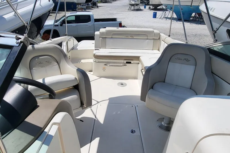 Slide: The Image of 2013 Sea Ray 260 Sundeck interior with seating and steering wheel, parked in a marina. - 14