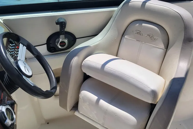 Slide: The Image of 2013 Sea Ray 260 Sundeck helm with steering wheel and branded seat. - 19