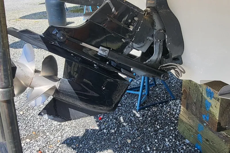 Slide: The Image of 2013 Sea Ray 260 Sundeck boat propeller and outdrive on gravel surface. - 4