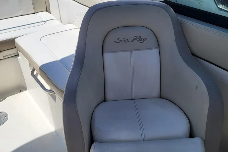 Slide: The Image of 2013 Sea Ray 260 Sundeck boat seat with logo, featuring white and gray upholstery. - 9