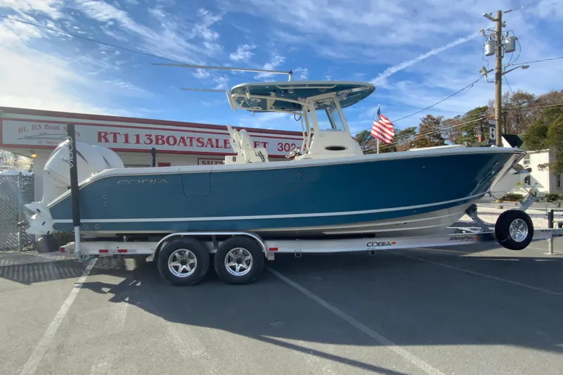 The Image of 2026 Cobia 285 Center Console boat on trailer at dealership. - 1