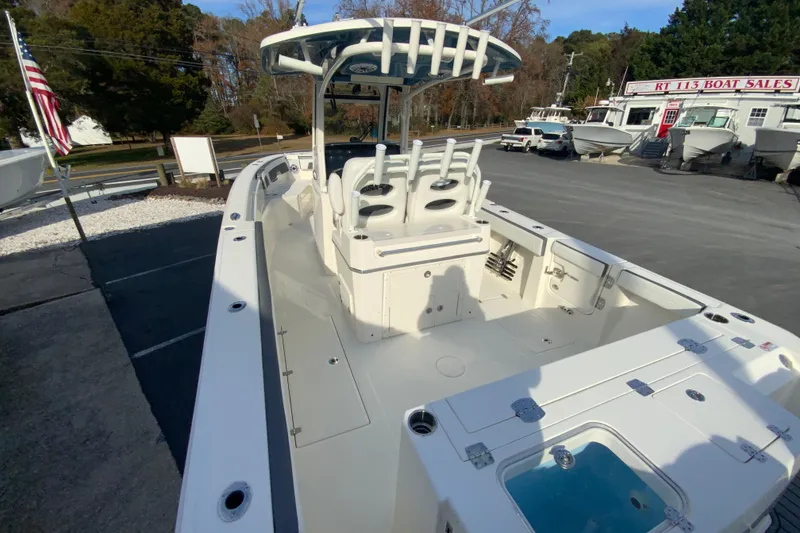 Slide: The Image of 2026 Cobia 285 Center Console boat at dealership, showcasing spacious deck and seating. - 10