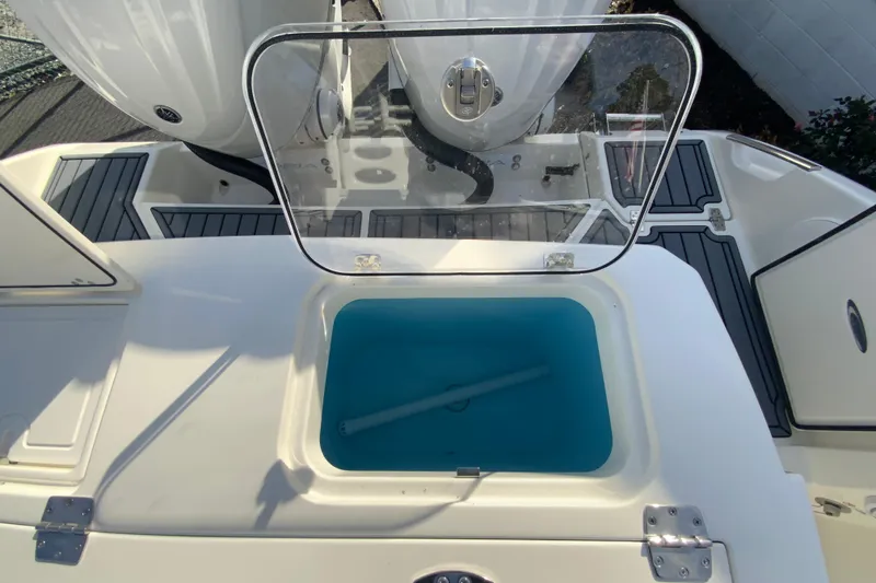 Slide: The Image of 2026 Cobia 285 Center Console boat with open livewell and dual outboard motors. - 15