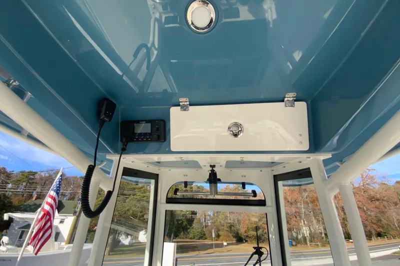 Slide: The Image of Interior view of 2026 Cobia 285 Center Console boat with blue ceiling and equipment. - 24