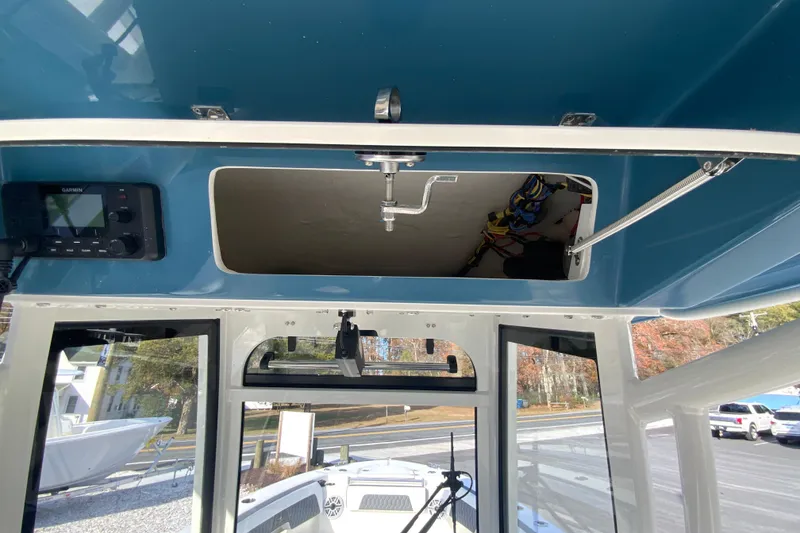 Slide: The Image of 2026 Cobia 285 Center Console boat interior with open storage compartment and electronic equipment. - 25