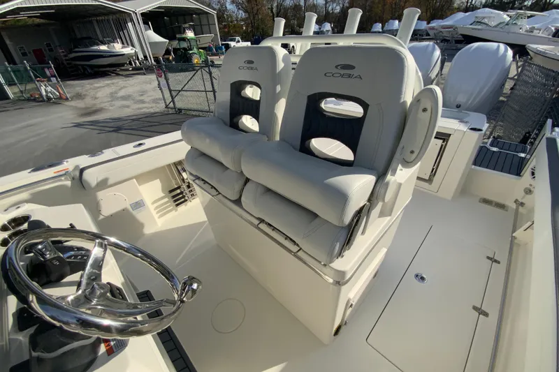 Slide: The Image of 2026 Cobia 285 Center Console boat interior with dual helm seats and steering wheel. - 26