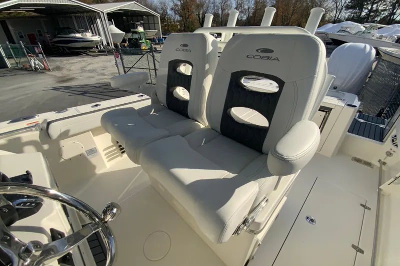 Slide: The Image of 2026 Cobia 285 Center Console boat with dual cushioned seats and steering wheel. - 27