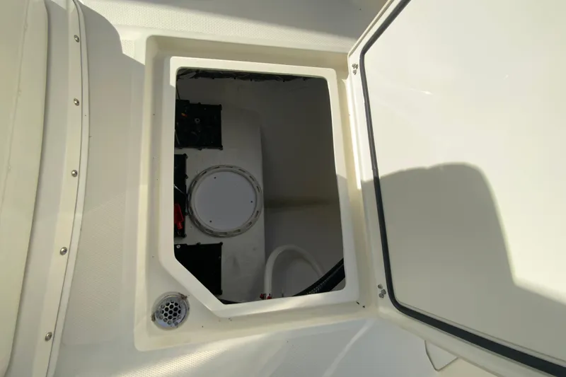 Slide: The Image of 2026 Cobia 285 Center Console storage compartment with open hatch, showcasing interior details. - 31