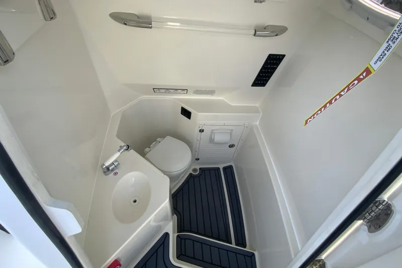 Slide: The Image of 2026 Cobia 285 Center Console boat interior bathroom with sink and toilet. - 40