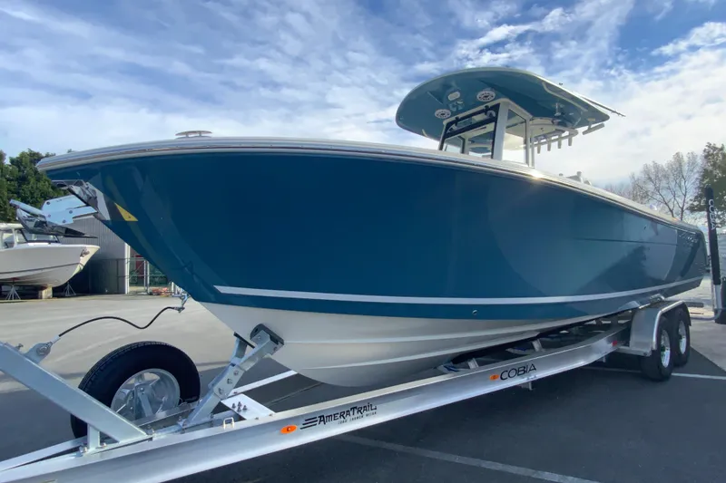 Slide: The Image of 2026 Cobia 285 Center Console boat on trailer under blue sky. - 5