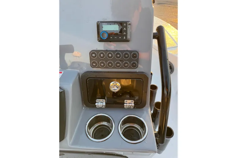Slide: The Image of Control panel of 2026 Blazer Bay 675 Ultimate Bay boat with switches and cup holders. - 14