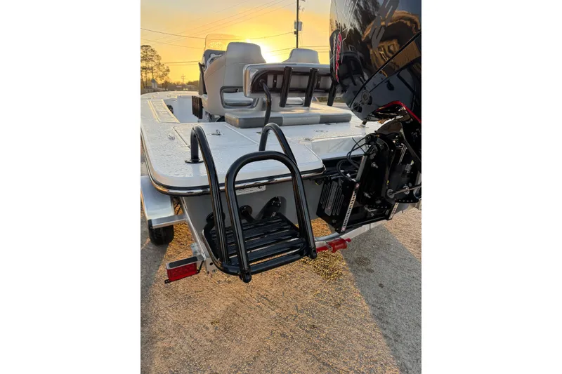 Slide: The Image of 2026 Blazer Bay 675 Ultimate Bay boat, rear view with ladder and motor at sunset. - 21