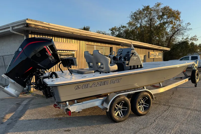 Slide: The Image of 2026 Blazer Bay 675 Ultimate Bay boat on trailer, parked outside a building. - 4