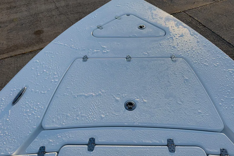 Slide: The Image of 2026 Blazer Bay 675 Ultimate Bay boat deck with water droplets, showcasing storage compartments. - 9