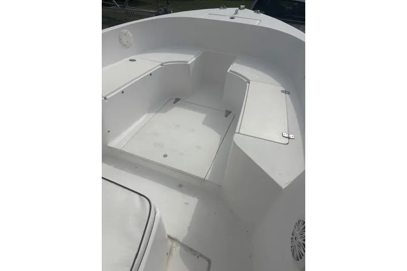 Slide: The Image of 1998 Mako 221 Center Console boat interior with white seating and storage compartments. - 13