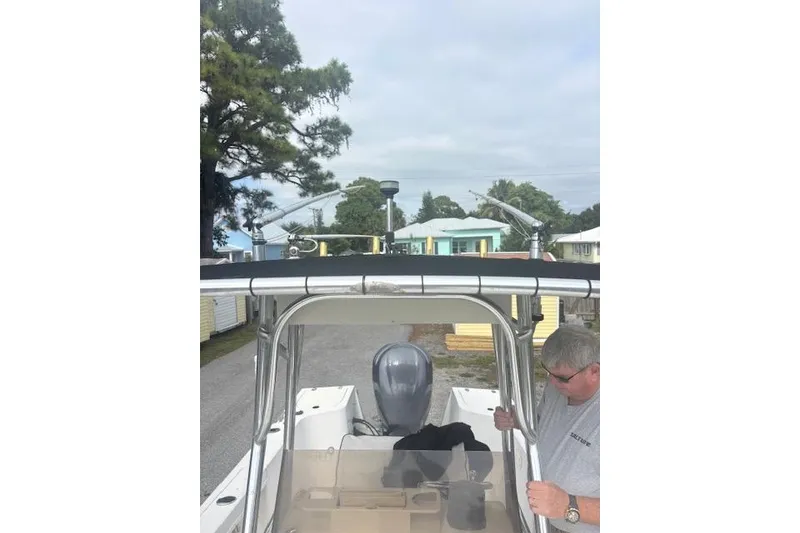 Slide: The Image of 1998 Mako 221 Center Console boat with a person standing nearby. - 14