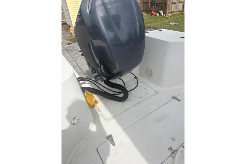 Slide: The Image of 1998 Mako 221 Center Console boat with outboard motor in a yard setting. - 8