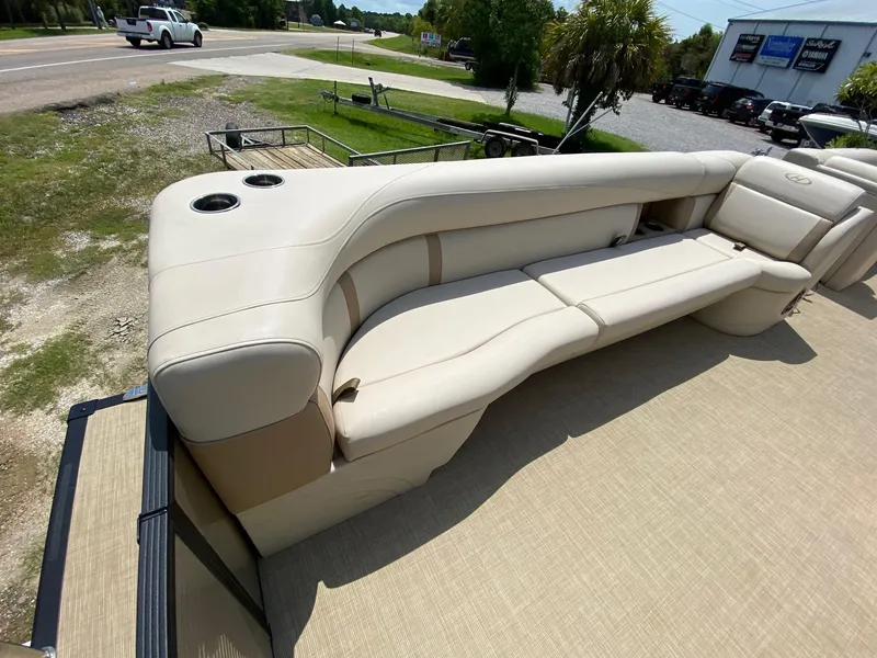 Slide: The Image of Beige seating on 2021 Harris 250 Cruiser boat, featuring cup holders and outdoor setting. - 5