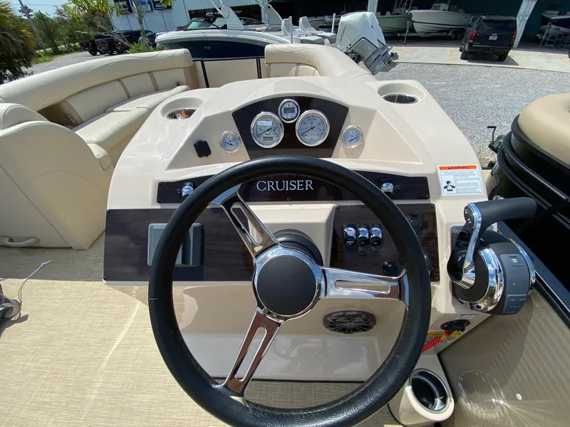 Slide: The Image of 2021 Harris 250 Cruiser boat dashboard with steering wheel and control panel. - 7