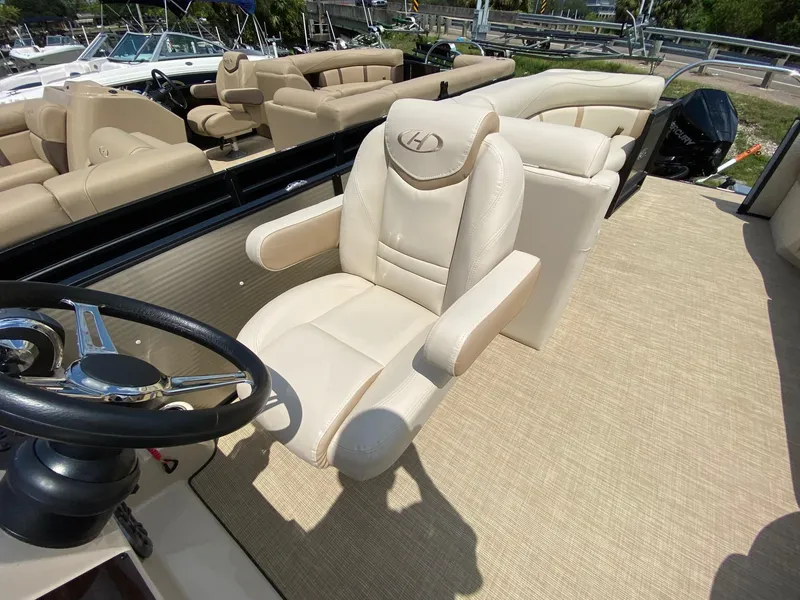 Slide: The Image of Luxurious seating on 2021 Harris 250 Cruiser boat with beige upholstery and steering wheel. - 9