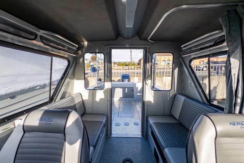 Slide: The Image of 2017 Hewescraft 240 Ocean Pro interior with seating and windows, showcasing spacious cabin design. - 23