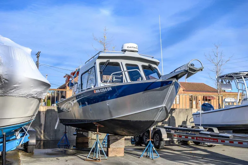 Slide: The Image of 2017 Hewescraft 240 Ocean Pro boat on stands, with clear blue sky background. - 27