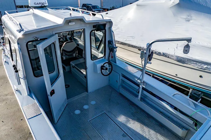 Slide: The Image of 2017 Hewescraft 240 Ocean Pro boat interior with open cabin door and steering wheel. - 7