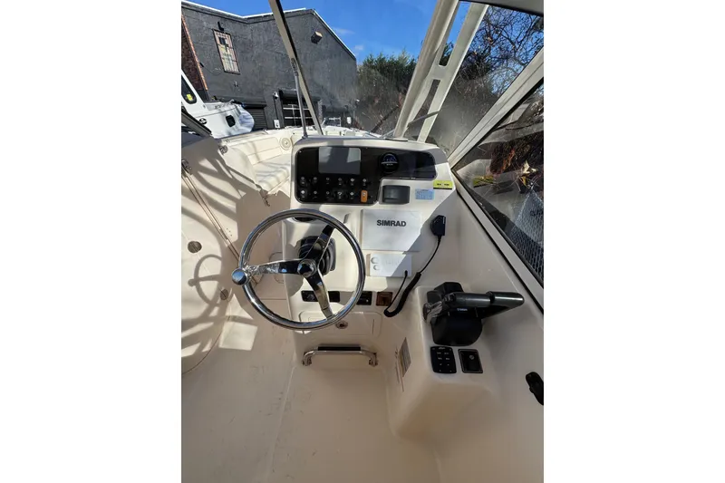 Slide: The Image of 2017 Grady-White Freedom 255 boat helm with steering wheel and Simrad electronics. - 6