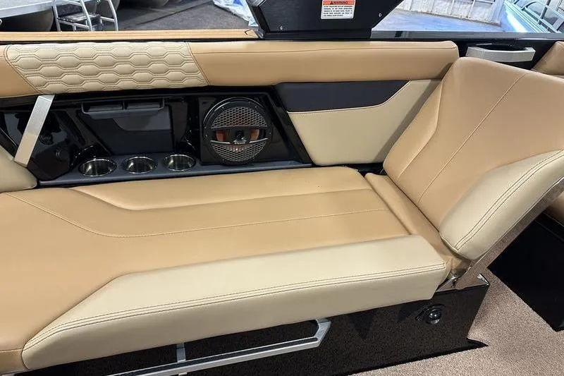 Slide: The Image of 2025 MasterCraft XT24 boat interior with tan leather seating and built-in speaker system. - 12