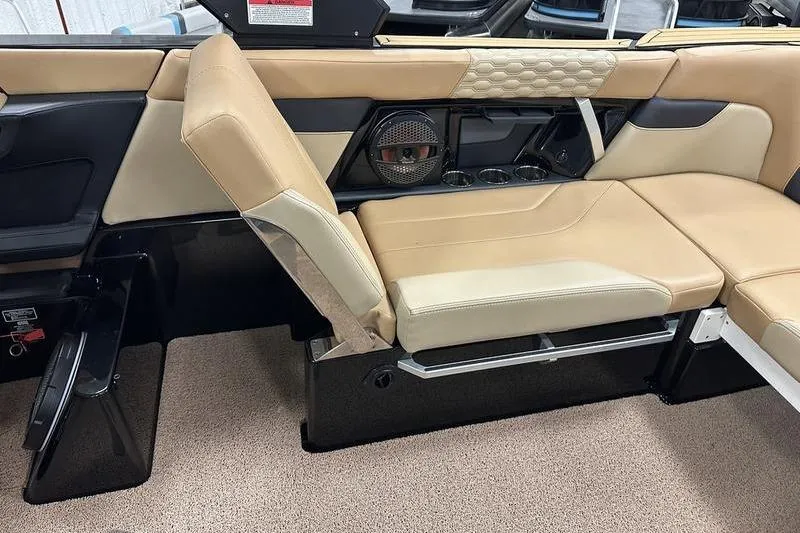 Slide: The Image of 2025 MasterCraft XT24 boat interior with beige seating and speaker system. - 19