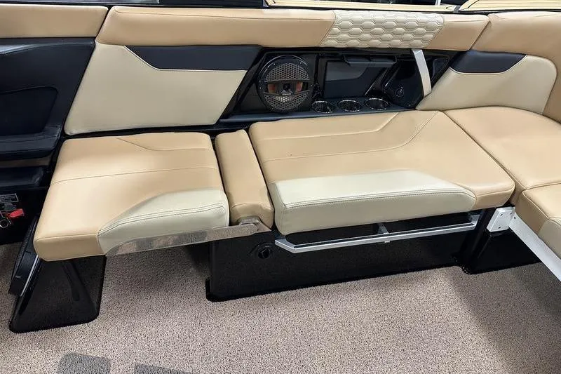Slide: The Image of 2025 MasterCraft XT24 interior seating with beige upholstery and integrated speaker system. - 20