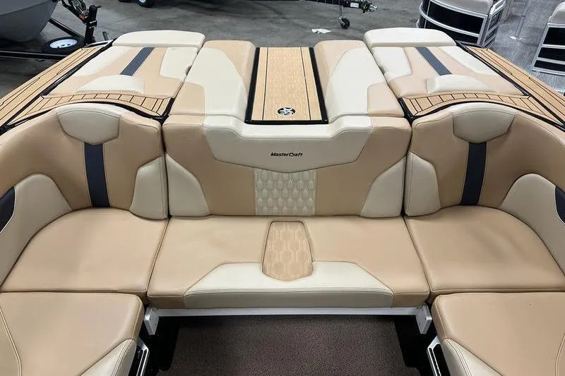 Slide: The Image of 2025 MasterCraft XT24 boat interior with beige and tan seating, showcasing luxury design. - 21