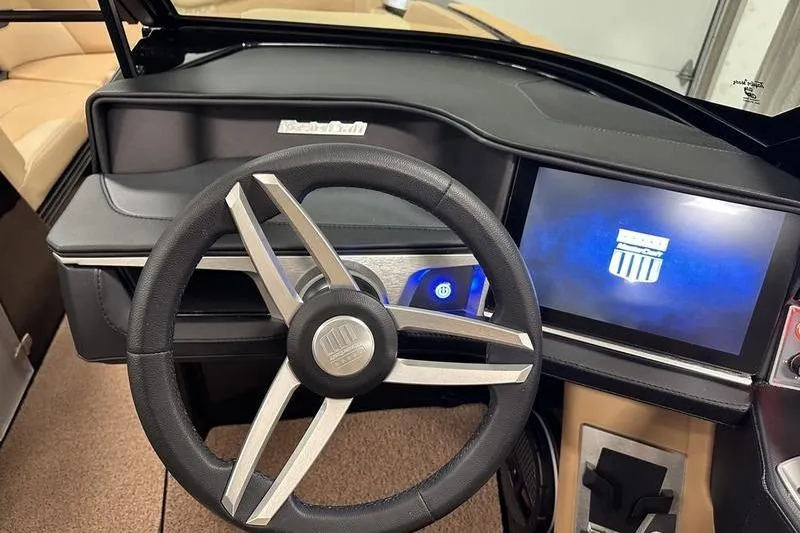 Slide: The Image of 2025 MasterCraft XT24 boat dashboard with steering wheel and digital display. - 34