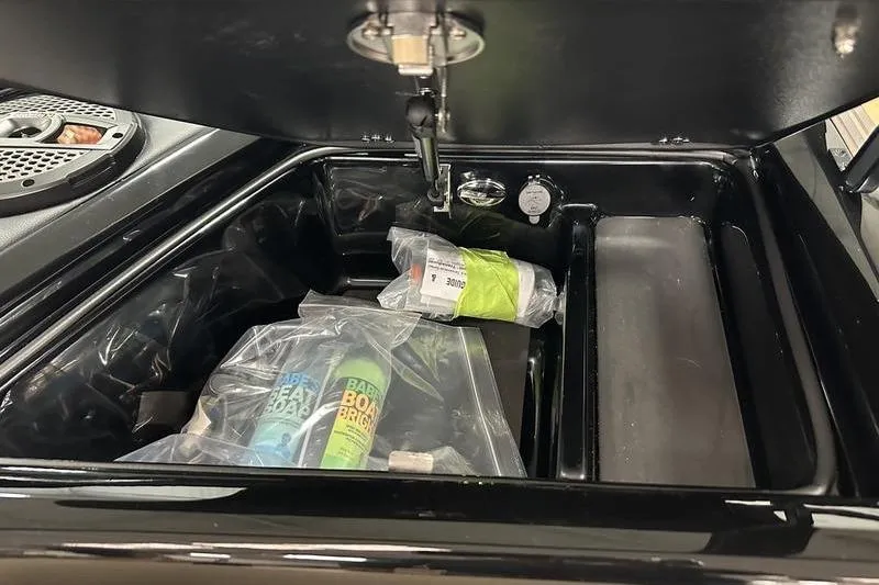 Slide: The Image of Open storage compartment in 2025 MasterCraft XT24 boat with cleaning supplies. - 38