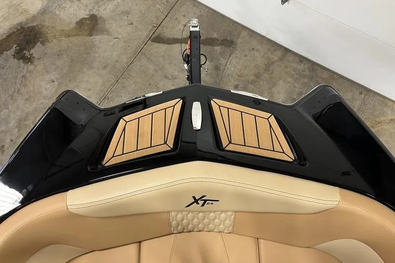 Slide: The Image of 2025 MasterCraft XT24 boat interior with tan seating and wooden accents. - 52