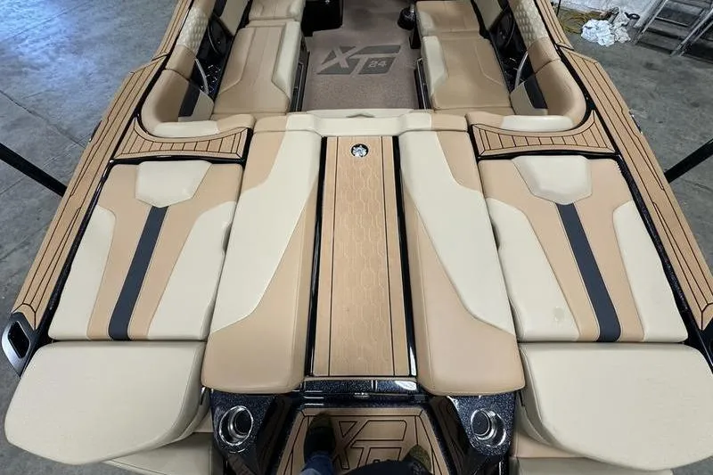 Slide: The Image of 2025 MasterCraft XT24 boat interior with beige and black seating design. - 9