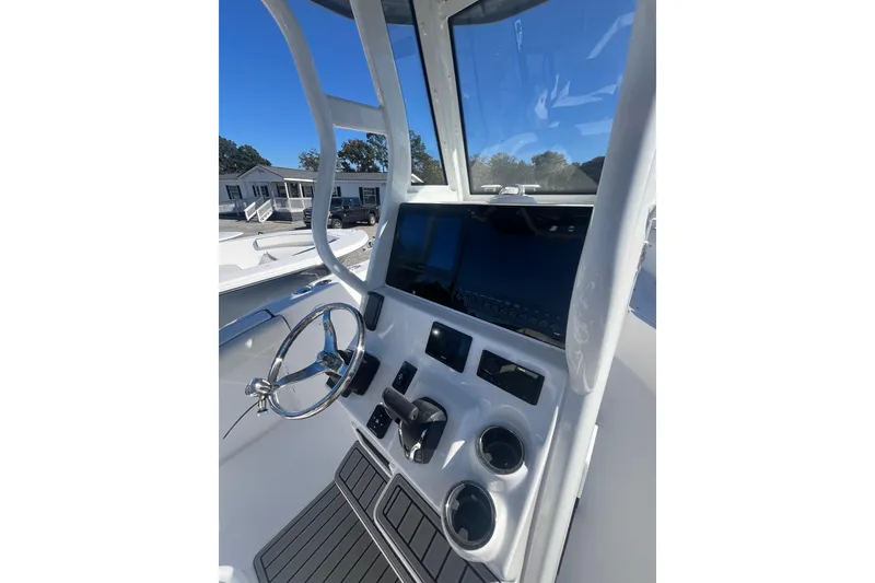 Slide: The Image of 2026 Tidewater 232 CC Adventure boat with ladder and trailer on gravel surface. - 10