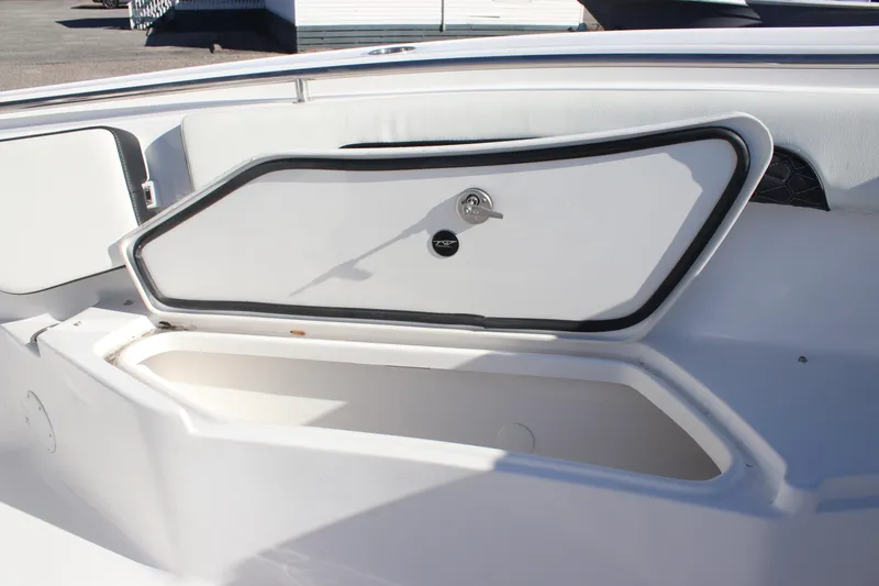 Slide: The Image of 2026 Tidewater 232 CC Adventure boat storage compartment with secure latch. - 13