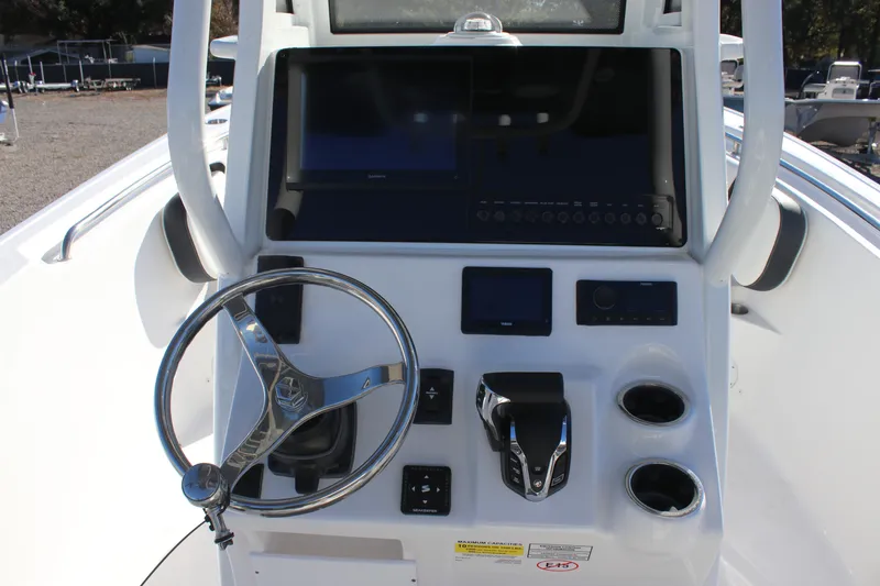 Slide: The Image of 2026 Tidewater 232 CC Adventure boat console with steering wheel and electronic controls. - 16