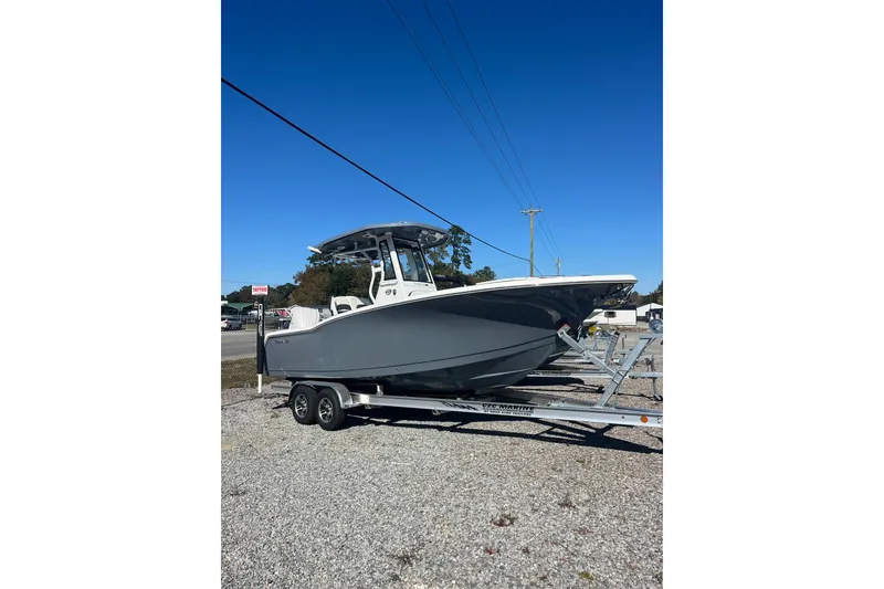 Slide: The Image of 2026 Tidewater 232 CC Adventure boat on trailer under clear blue sky. - 19
