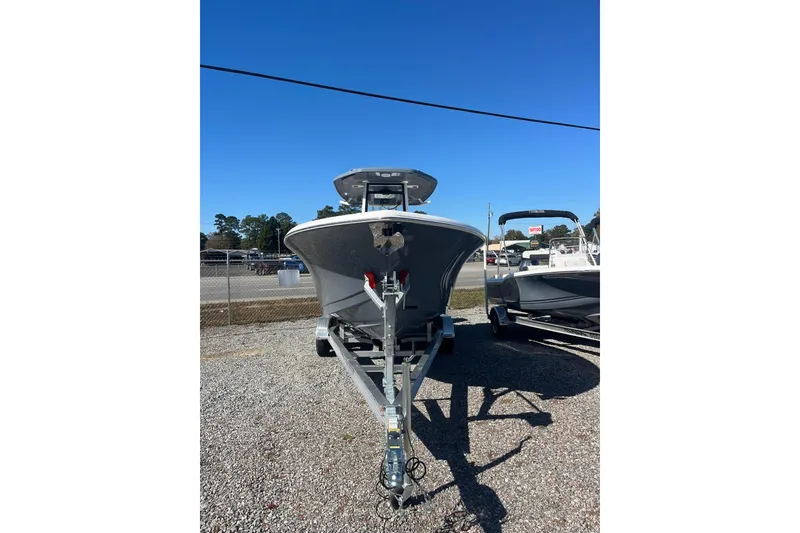 Slide: The Image of 2026 Tidewater 232 CC Adventure boat on trailer, front view, outdoors. - 3