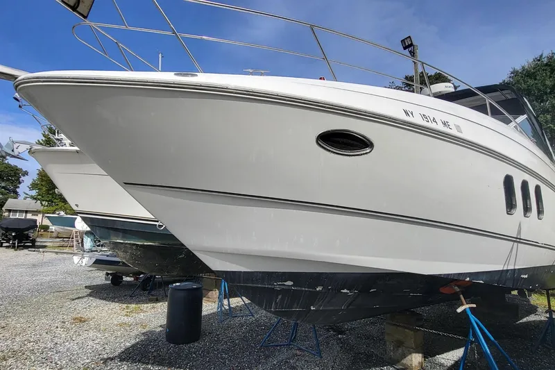 The Image of 2008 Cruisers 330 boat on dry dock, white hull, outdoor storage. - 0