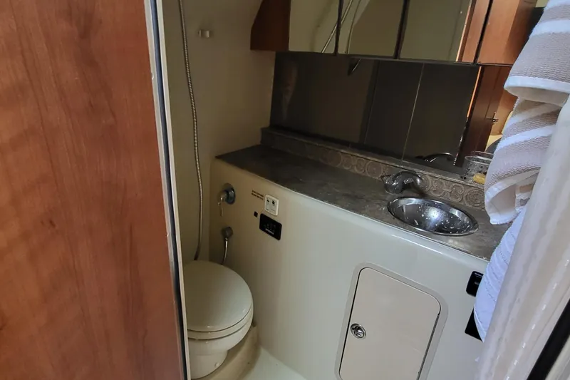 Slide: The Image of 2008 Cruisers 330 yacht bathroom with sink, toilet, and mirror. - 12