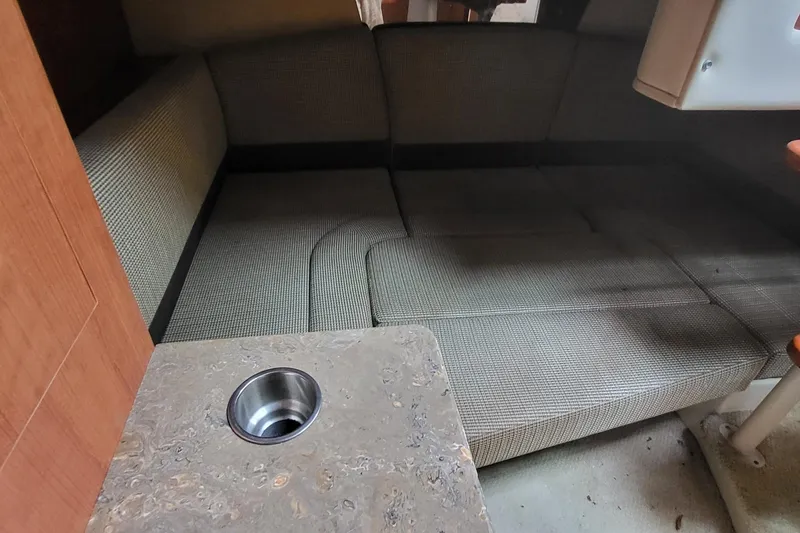 Slide: The Image of 2008 Cruisers 330 interior with cushioned seating and a countertop with a cup holder. - 16