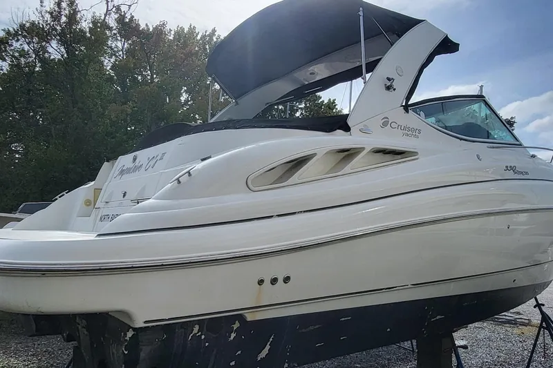 Slide: The Image of 2008 Cruisers 330 yacht with canopy, docked outdoors, side view. - 2