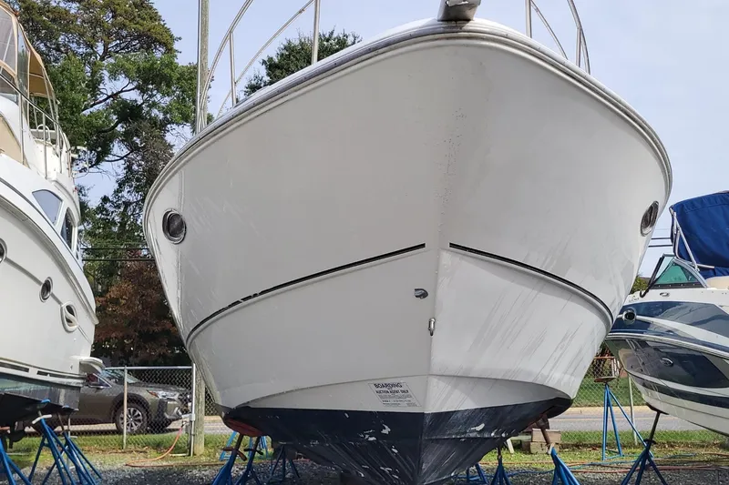 Slide: The Image of 2008 Cruisers 330 boat on stands, surrounded by other boats, outdoors. - 5